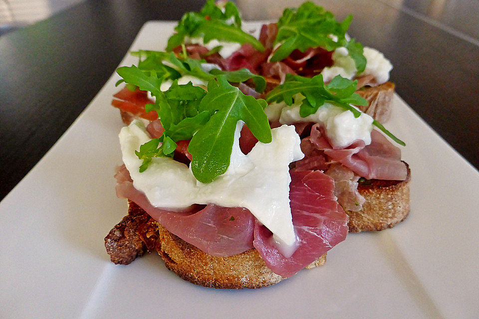 Crostini mit Rucolapesto, Prosciutto und Büffelmozzarella