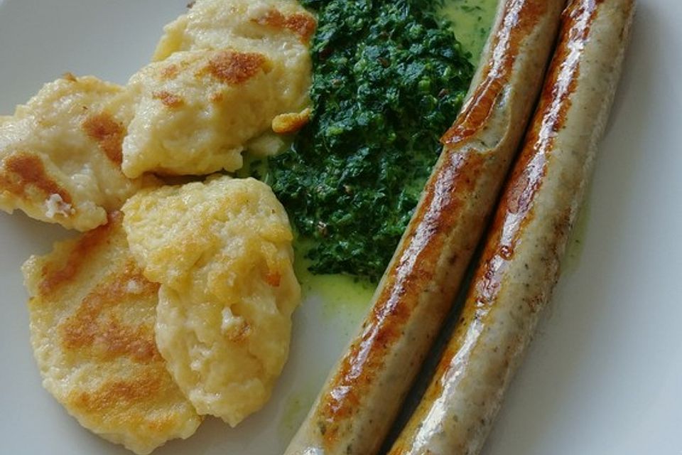 Mehlklöße mit Spinatsoße und Bratwurst