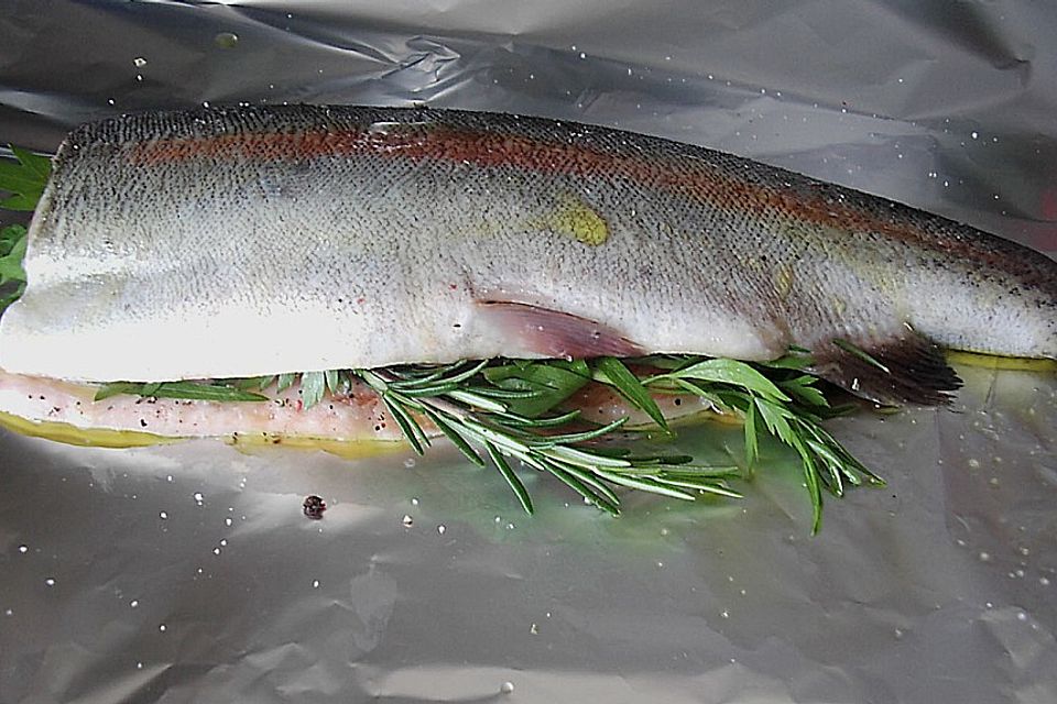 Regenbogenforelle mit Tomaten in Alufolie gegart