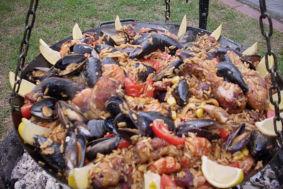 Meeresfrüchte - Paella auf dem Schwenkgrill über Holzkohle