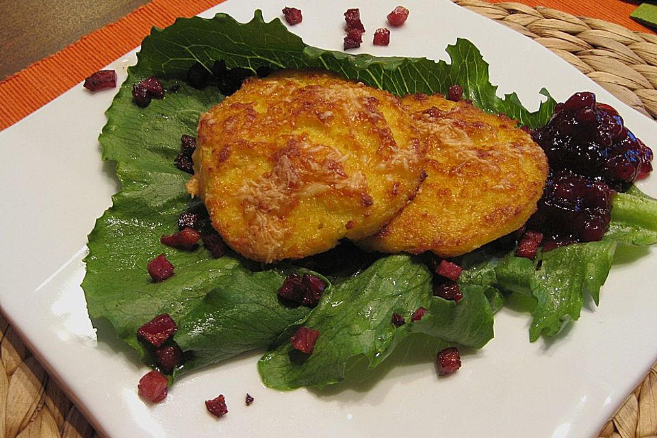 Überbackene Polenta - Taler mit Ziegenkäse an Wildbeergelee auf Salat mit gebratenen Schinkenwürfeln