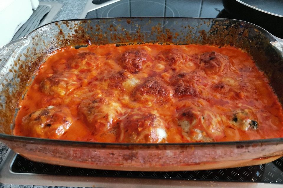 Hackbällchen gefüllt mit Fetakäse in einer Tomatensoße überbacken