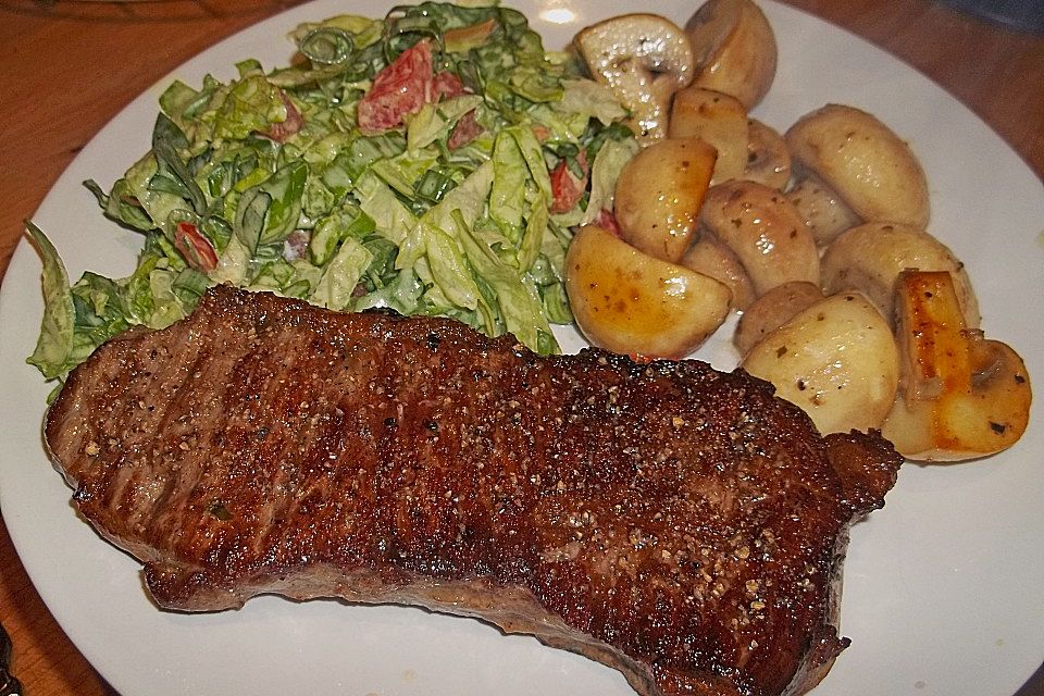 Rumpsteak mit gespeckmantelten Bohnen und Rosmarinkartöffelchen, dazu Champignons