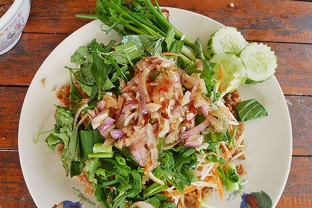 Thailändischer sauerscharfer Fischsalat mit grünen Mangos und Kräutern ...