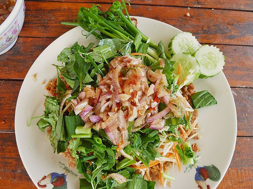 Thailändischer sauerscharfer Fischsalat mit grünen Mangos und Kräutern ...