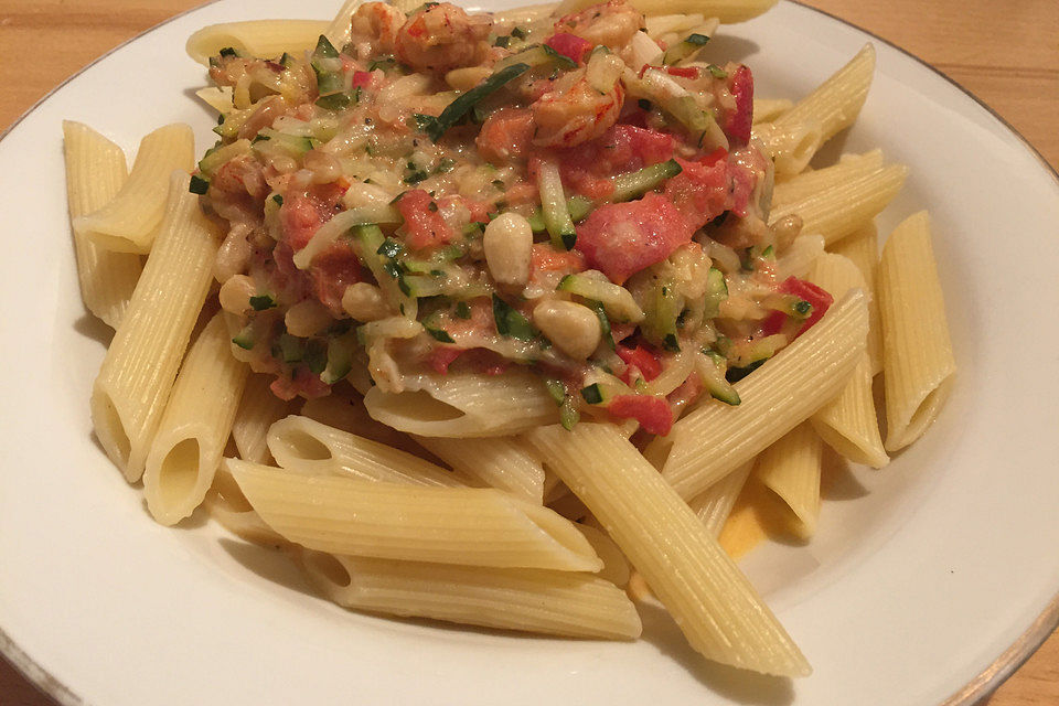 Penne mit Flusskrebsschwänzen an Pinienkernen, Tomaten und Zucchini