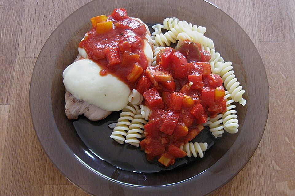 Überbackene Putenschnitzel vom Grill mit scharfer Tomatensoße