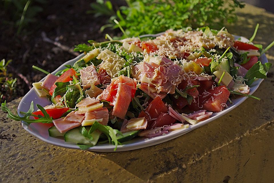 Rucolaplatte mit Tomaten und Gurken mit Balsamicodressing