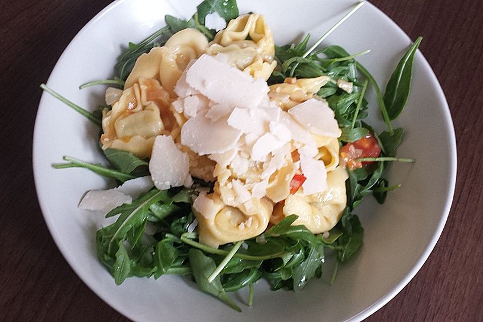 Ricotta-Tortellini mit Rucola, Tomaten und Pinienkernen