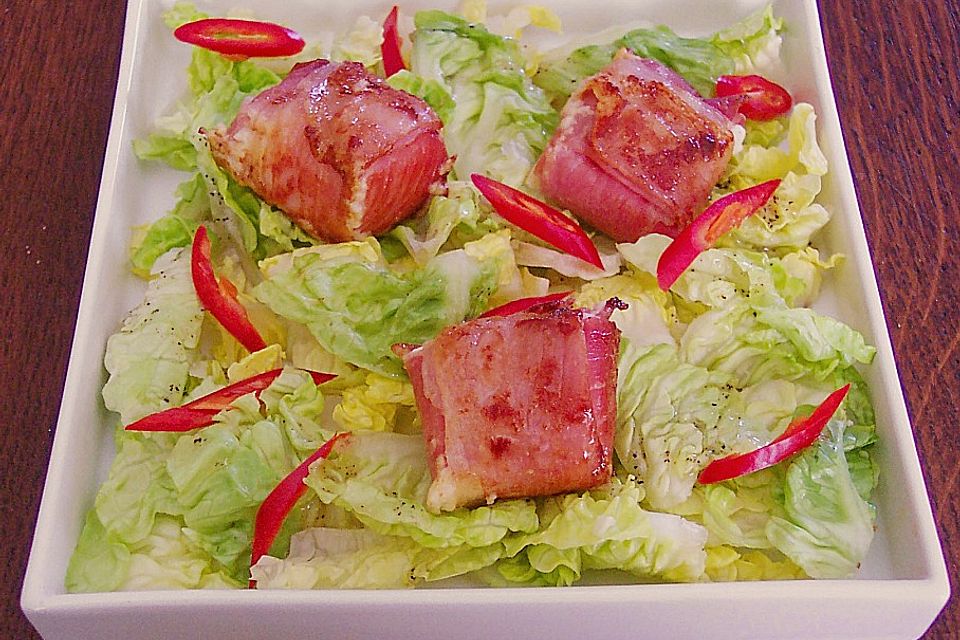 Fetakäse im Schinkenmantel auf Blattsalat