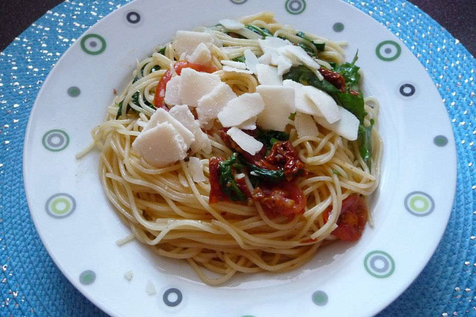 Spaghetti auf angebratenen, sonnengetrockneten Tomaten mit Rucola und Parmesan