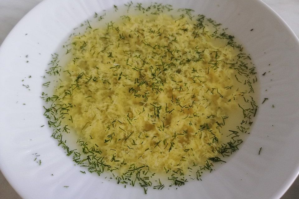 Klare Spargelsuppe mit Eierblumen und frischen Kräutern