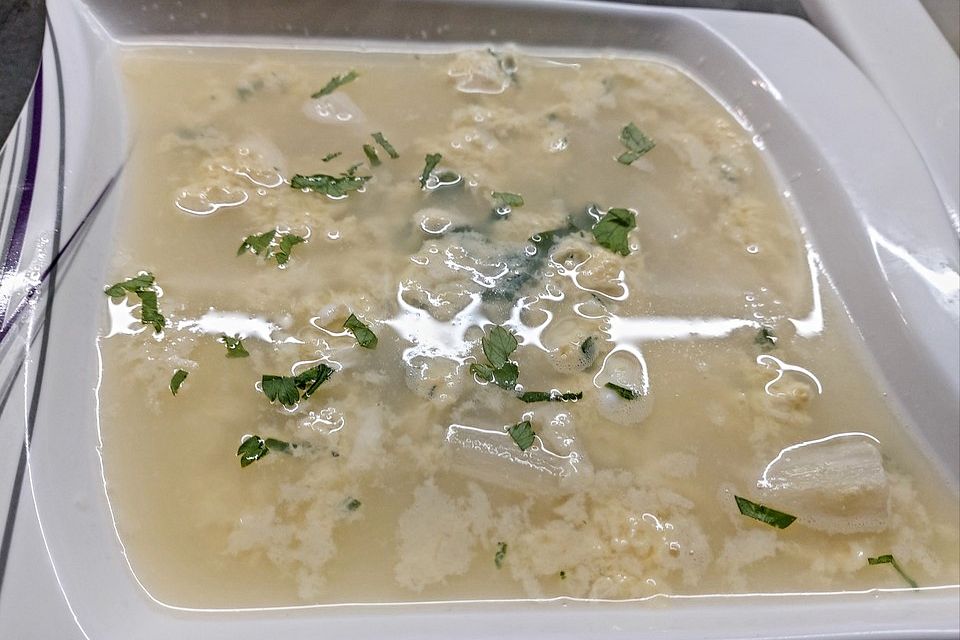 Klare Spargelsuppe mit Eierblumen und frischen Kräutern