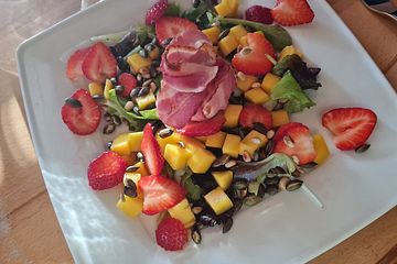 Gebackener Ziegenkäse im Speckmantel auf fruchtigem Salat mit Honig-Senf-Vinaigrette