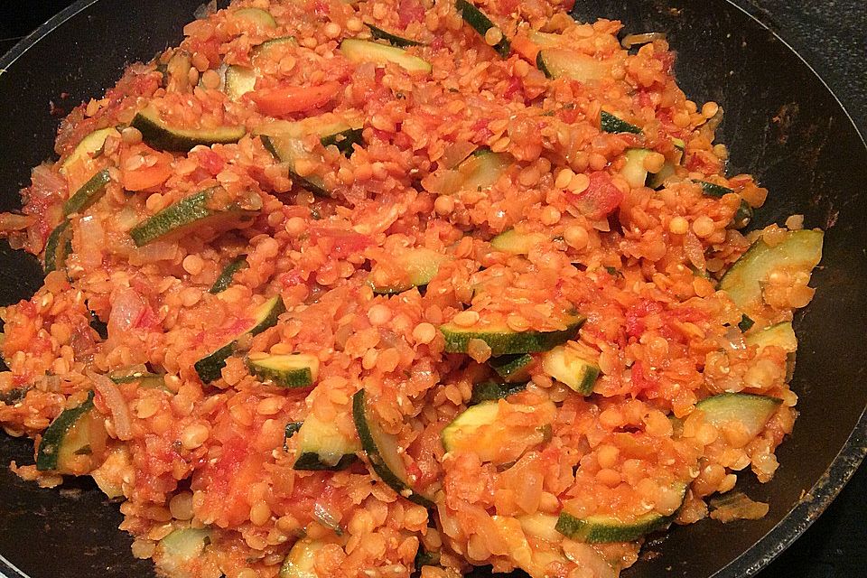 Exotische Gemüsepfanne mit roten Linsen, Zucchini, Tomaten und Nektarine