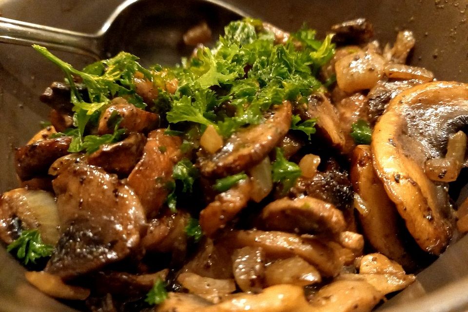 Frische Champignons mit Zwiebeln gebraten