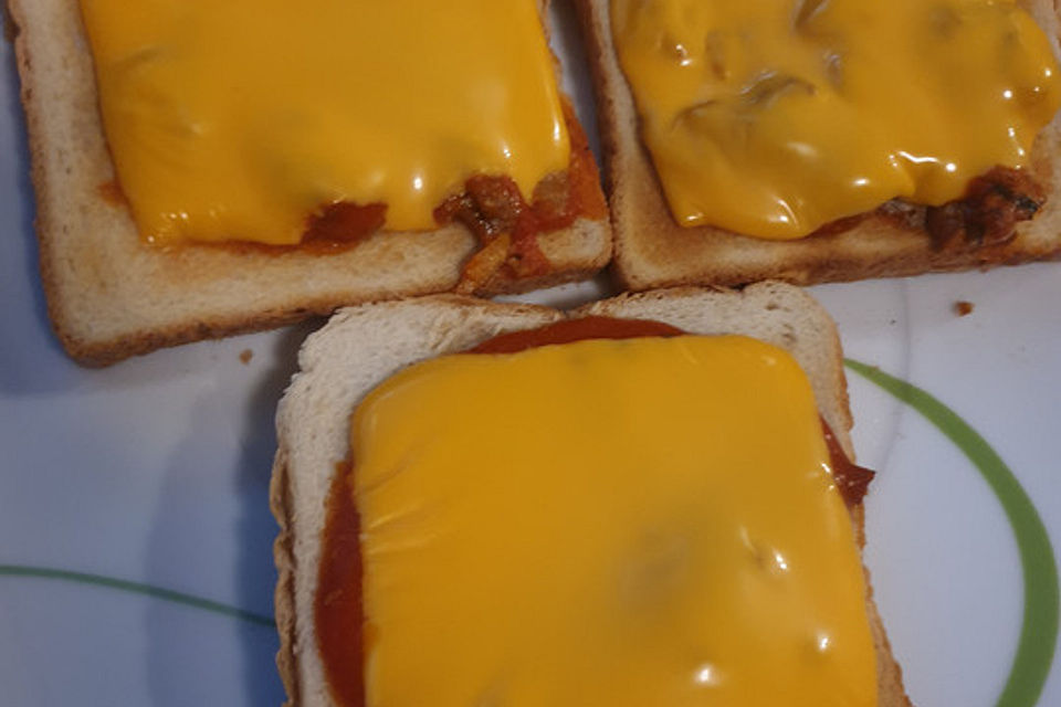 Brötchen mit Scheiblettenkäse und Heringsfilet in Tomatensoße gebacken