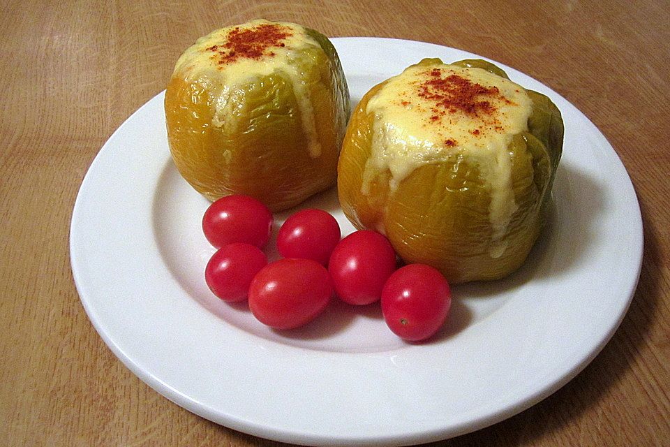 Paprika gefüllt mit pikantem Parmesan-Reis und einer Tomate