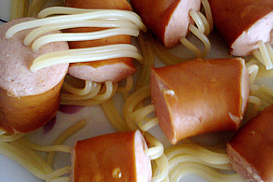 Bockwurst auf Spaghetti aufgespießt