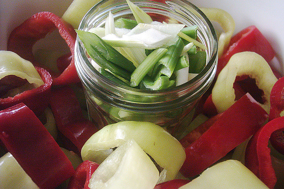 Spitzpaprikagemüse (rot und gelb) mit Frühlingszwiebel an Wildreis-Kegel