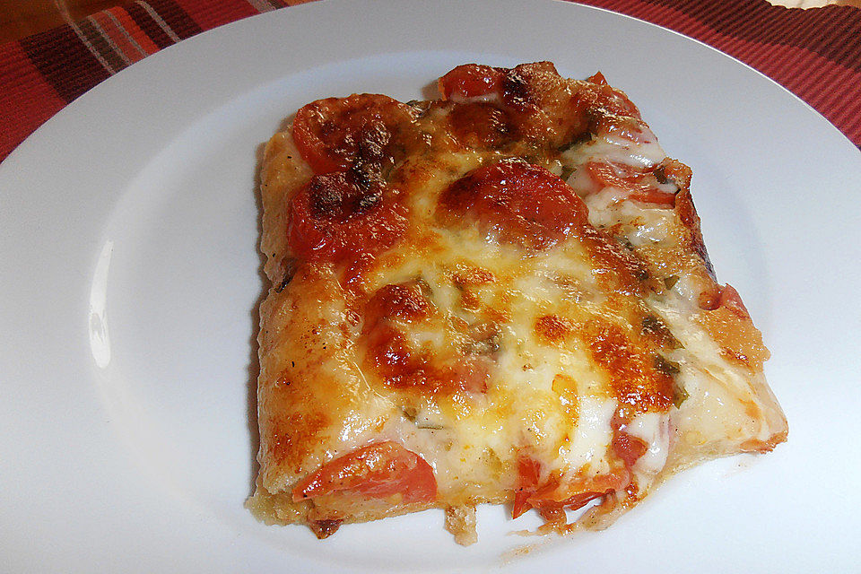 Pizza mit Tomaten, Basilikum, Mozzarella und Parmesan