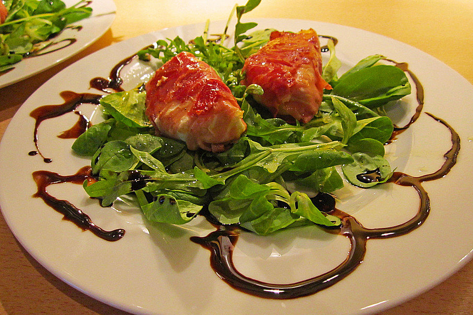 Ziegenkäseröllchen im Parmaschinkenmantel auf Feldsalat