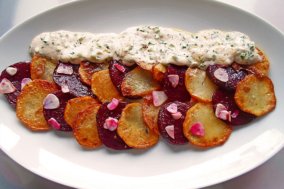 Gebratene Kartoffel- und Rote Bete-Scheiben mit Knoblauch an Petersilien-Schmand-Soße