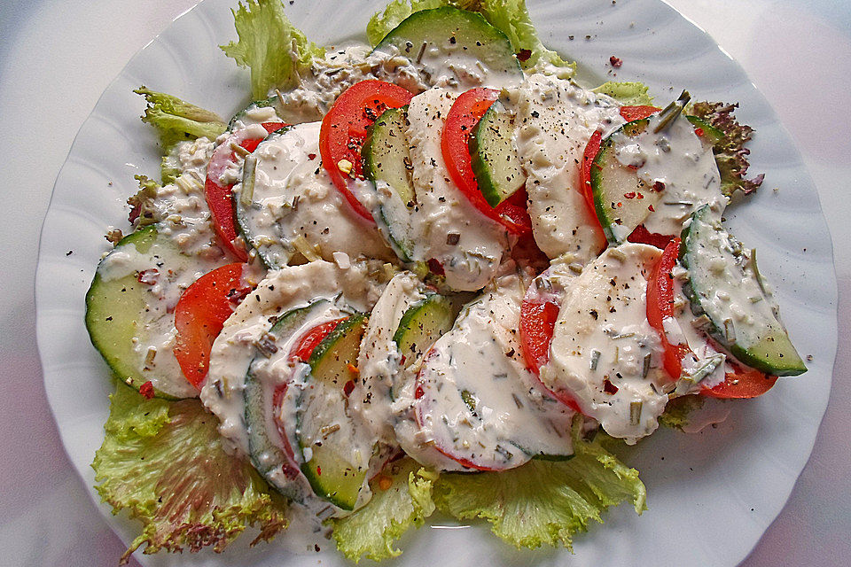 Trilogie von Gurke-Tomate-Mozzarella auf Lollo Bianco-Bett mit Joghurt-Schnittlauch-Dressing