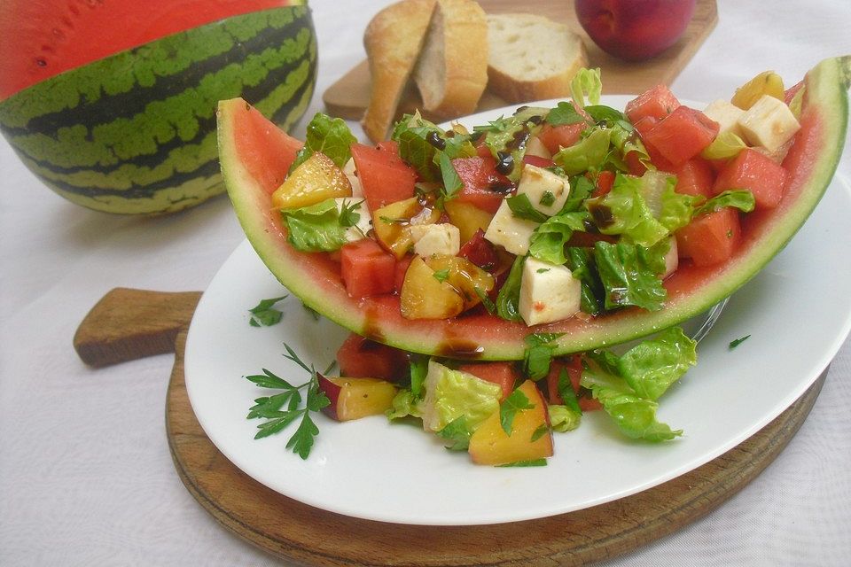 Mozzarella-Melonen-Nektarinen-Salat mit grünen Salatblättchen unter Walnussessig-Balsamicocreme-Dressing