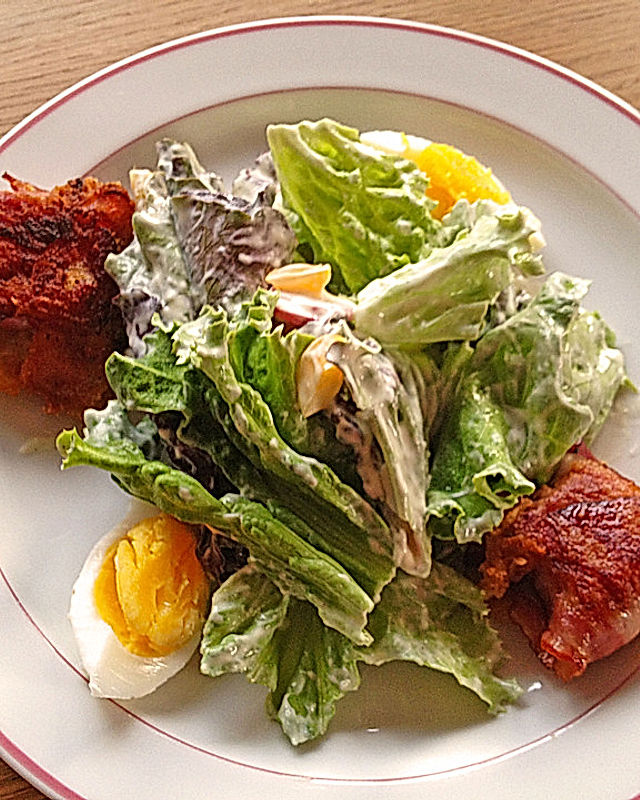 Grüner Salat mit Ei und Brie-Käse im Speckmantel