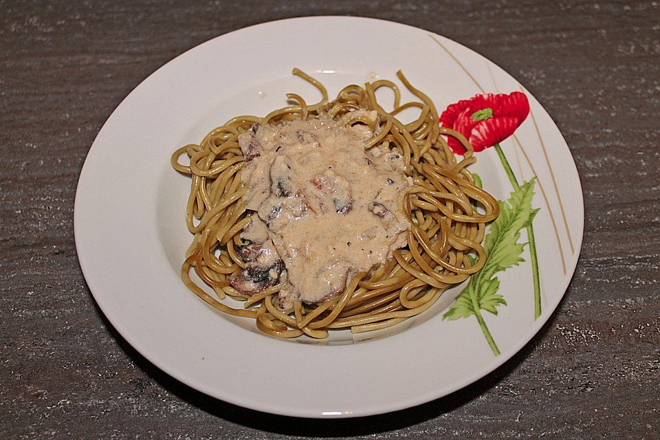 Grüne Bandnudeln mit frischen Champignons in einer Parmesan-Sahnesoße