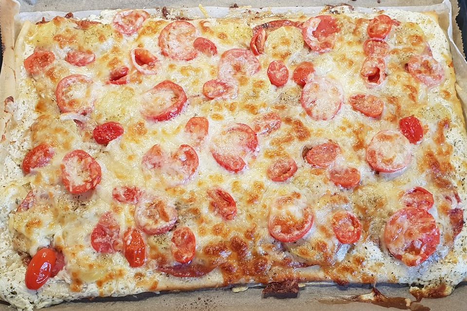 Kartoffelpizza mit Tomate, Mozzarella und Bacon