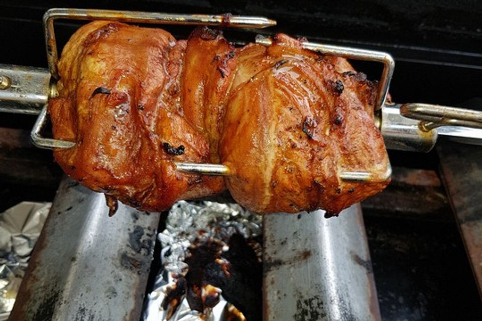 Spießbraten oder Krustenbraten vom Grill mit Brötchen