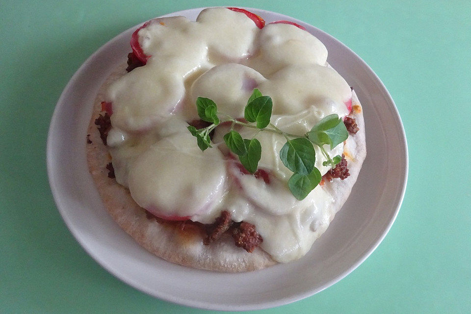 Hackfleisch-Pizza mit Tomaten und Mozzarella