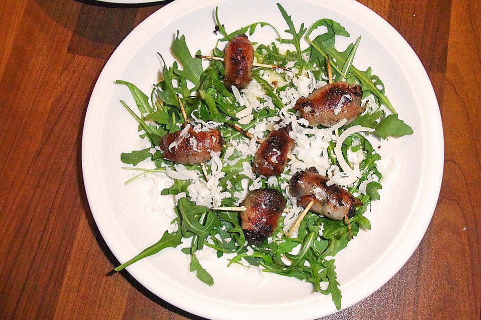 Pflaumen und Datteln im Speckmantel auf Rucola-Salat