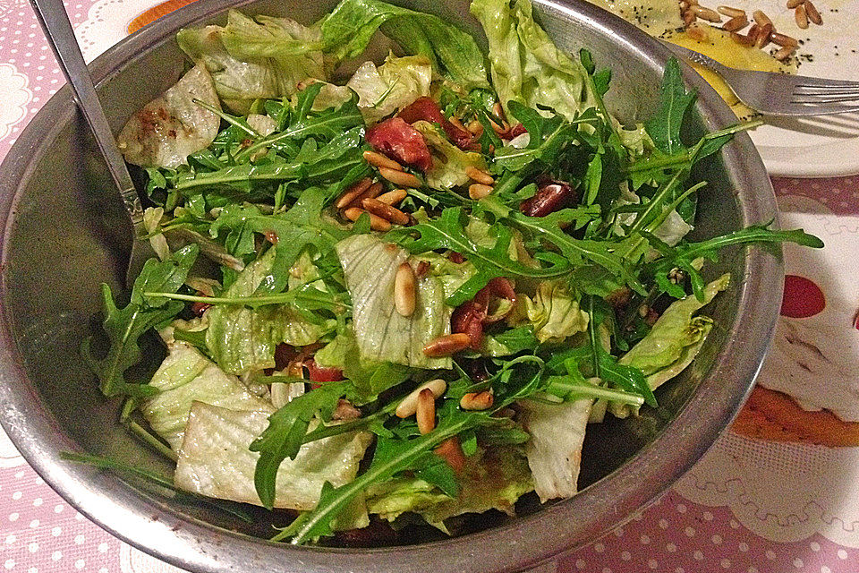 Salat mit Rucola, Pinienkernen und Schinkenfrischkäseröllchen