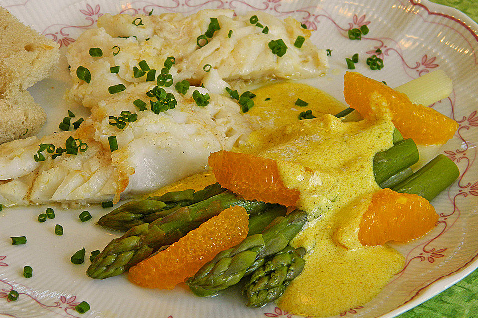 Kabeljaufilet auf grünem Spargel an Orangen-Curry-Sauce