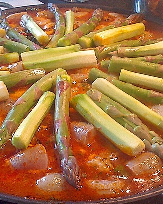 Frühlings-Paella mit Huhn, Fisch, Shrimps und grünem Spargel