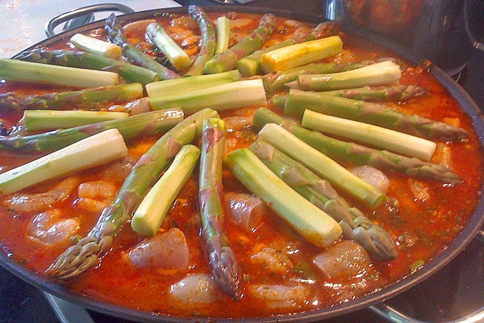 Frühlings-Paella mit Huhn, Fisch, Shrimps und grünem Spargel