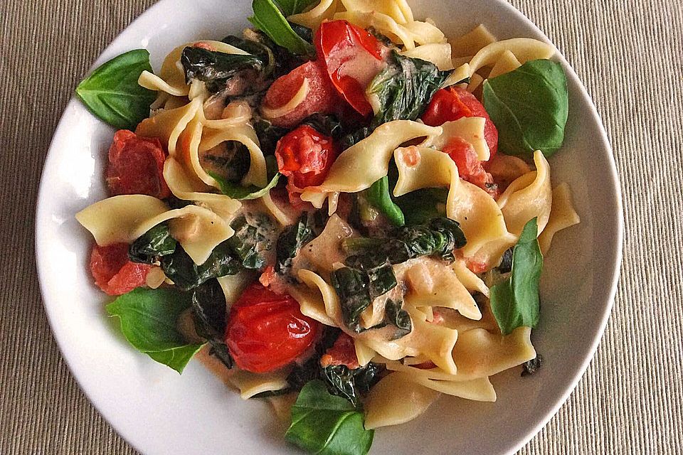 Bandnudeln in Zitronensoße mit Blattspinat und Tomaten