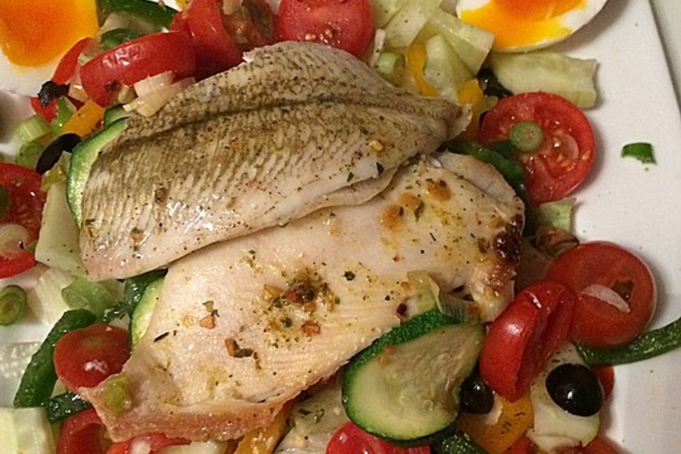 Fischfilet auf Tomatengemüse im Salatbett