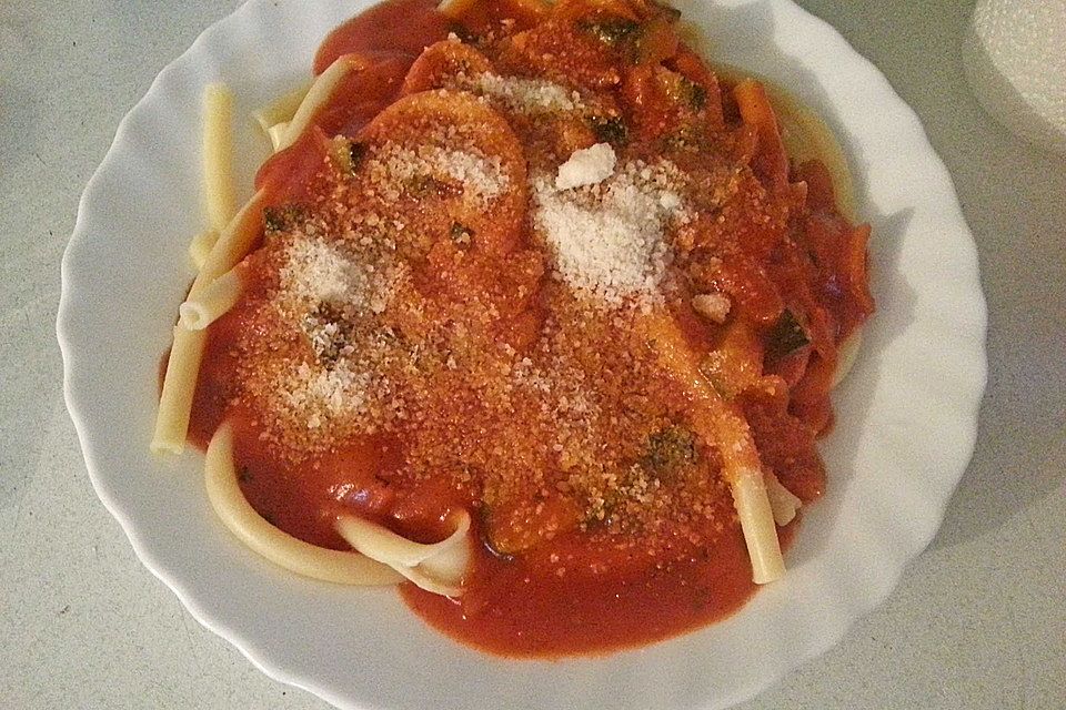 Makkaroni mit fruchtiger Tomatensoße mit Zwiebeln und Zucchini