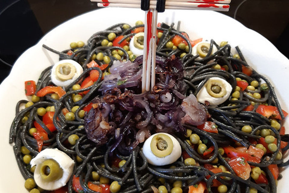 Nudelsalat aus schwarzen Spaghetti mit Augen