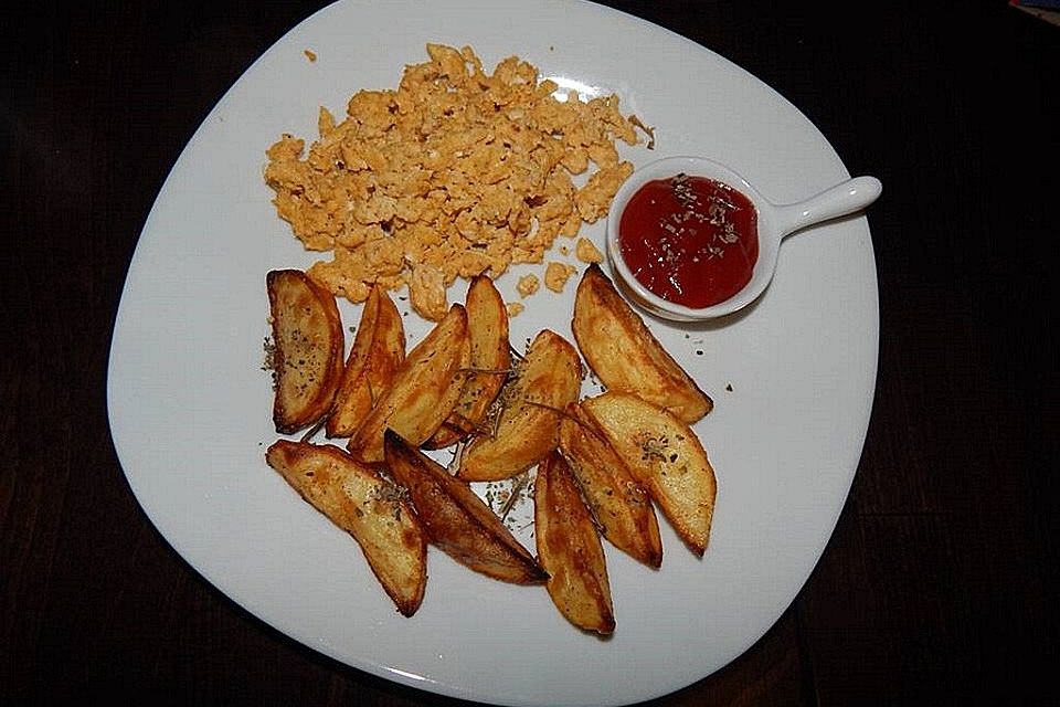 Leckere Kartoffelecken an Rührei, verfeinert mit Kräutern aus dem Garten