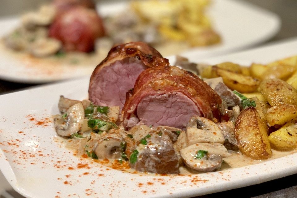 Ganzes Schweinefilet im Speckmantel mit  Kräuter-Rahm-Champignons nach Jägerart