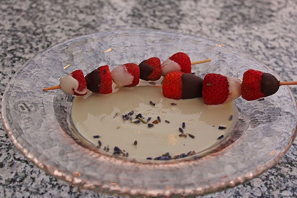 Creme von Lavendelblüten mit dunklen und hellen Erdbeerspießchen