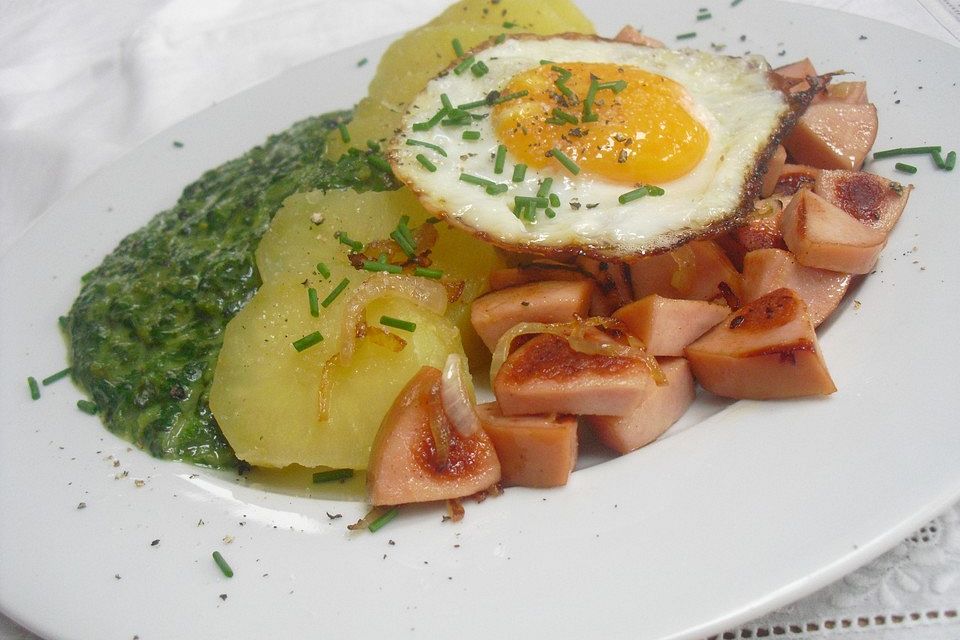 Gebratene Fleischwurstwürfel mit Kartoffeln, Spinat und Spiegelei