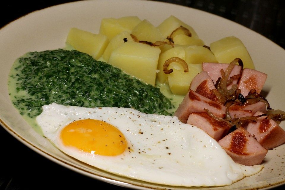 Gebratene Fleischwurstwürfel mit Kartoffeln, Spinat und Spiegelei