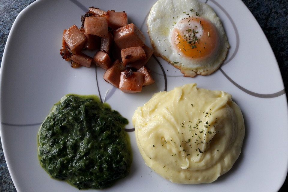 Gebratene Fleischwurstwürfel mit Kartoffeln, Spinat und Spiegelei