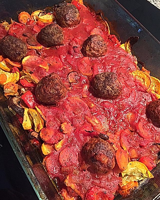 Hackfleisch-Feta-Bällchen in cremiger Tomatensoße an Ofengemüse